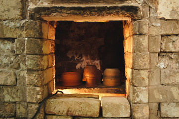 Clay pot and jug in brick pottery kiln. Element of authentic workshop.