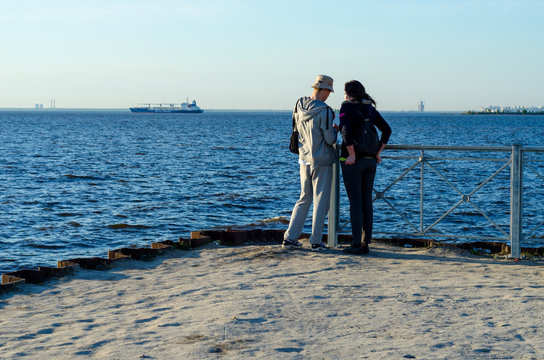 Two lovers on the background of the sea. Romantic couple at sunset. Girl and the guy on the background of the ocean. Russia, St. Petersburg, June 20, 2017
