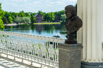 Cameron Gallery in Tsarskoye Selo. Male bust in the background of the panorama of the Catherine Park, St. Petersburg, Russia, July 17, 2017