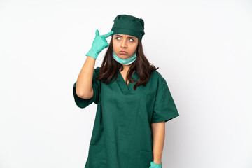 Surgeon woman in green uniform isolated on white background making the gesture of madness putting...