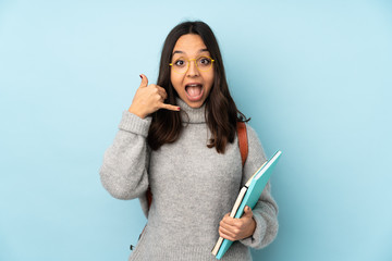 Young mixed race woman going to school isolated on blue background making phone gesture. Call me back sign