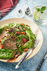 Warm salad with beef, cherry tomatoes and sun-dried tomatoes. Healthy food