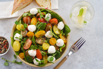 Salad with mozzarella, spinach and cherry tomatoes. Healthy eating. Vegetarian dish