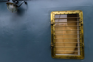 Bronze porthole of the ship on a gray background