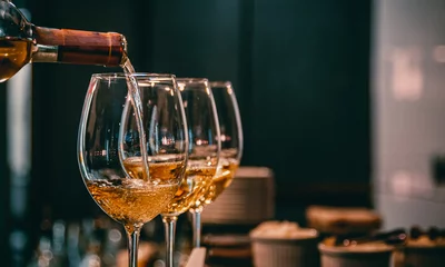 Fotobehang bartender pouring white wine into a glass in cafe or bar © pavel siamionov