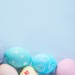 Colorful Easter eggs dyed by colored water with beautiful pattern on a pale blue background, design concept of holiday activity, top view, copy space.