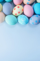 Colorful Easter eggs dyed by colored water with beautiful pattern on a pale blue background, design concept of holiday activity, top view, copy space.