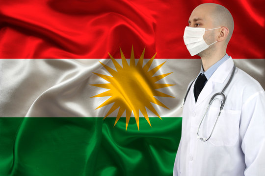 male doctor with a stethoscope on the background of the silk national flag of Kurdistan, rojava, concept of national medical care, health, insurance, tourism