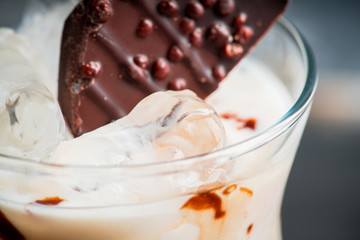 Creamy cocktail with ice and slice of chocolate. Selective focus. Shallow depth of field.