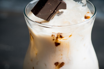 Creamy cocktail with ice and slice of chocolate. Selective focus. Shallow depth of field.