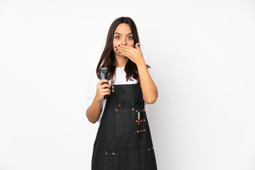 Fototapeta premium Young hairdresser woman isolated on white background covering mouth with hands