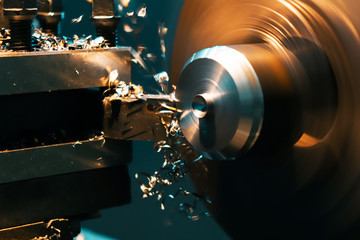 A turner grinds a part from an iron rod on a lathe. Metalworking parts on a lathe.