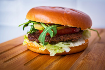 Homemade hamburger on wooden cutting board