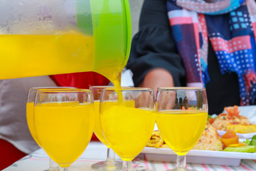 orange mocktail pouring into the glass