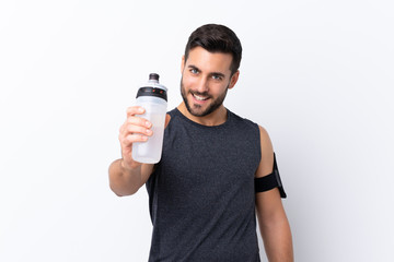 Young sport handsome man with beard over isolated white background with sports water bottle