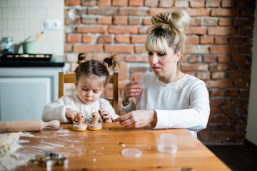 Mother and daughter baking cookies in their kitchen