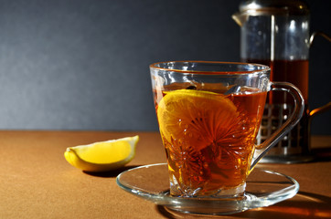 Cup and kettle with tea and lemon on a gray background horizontal orientation