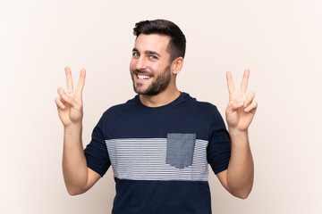 Naklejka premium Young handsome man with beard over isolated background showing victory sign with both hands