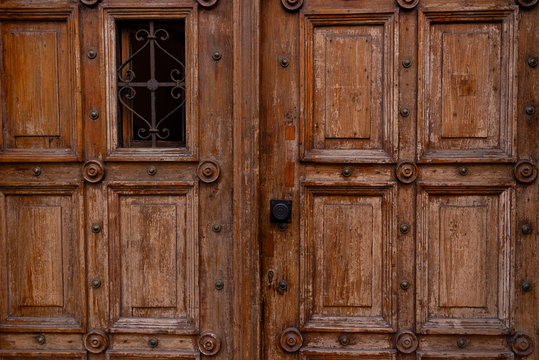 Ancient closed vintage wood door closeup. Entrance door with door handle