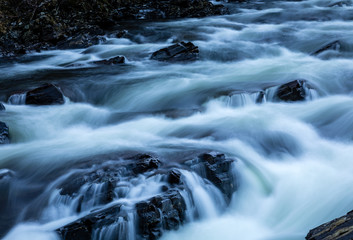 Long exposure shot of the waterfalls in Glen Orchy near Bridge of Orchy in the Argyll region of the highlands of Scotland during winter whilst the river is flowing fast from rainfall