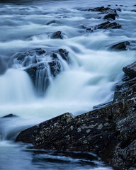 Long exposure shot of the waterfalls in Glen Orchy near Bridge of Orchy in the Argyll region of the highlands of Scotland during winter whilst the river is flowing fast from rainfall