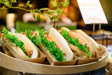 hotdog , sausage sandwishes with green vegetable
