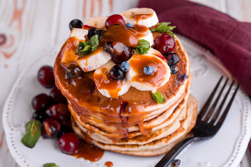 Delicious and lush pancakes with fresh fruits and berries, poured with salted caramel.
