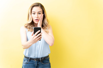 Fototapeta premium Surprised Caucasian Woman Using Cellphone