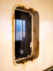 Close up of the maritime vessels rusty poorly maintained window of the vessel.