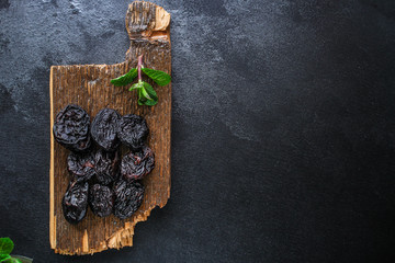 prunes, dried plums (tasty and healthy fruits) desiccated keto or paleo diet menu concept. background. top view. copy space