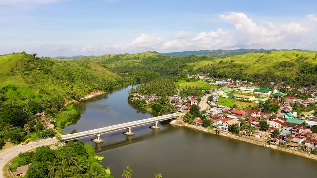 Road bridge on the island of Samar, Philippines.Town on the river bank and road bridge, top view. Bridge over the river, tropical landscape in the afternoon. Summer and travel vacation concept.