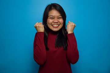 Fototapeta premium Portrait of Young beautiful asian women with blue isolated background, Excited and Happy Gesture