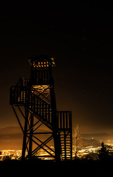 Fire Tower And Town Illuminated At Night