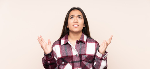 Young Indian woman isolated on beige background stressed overwhelmed