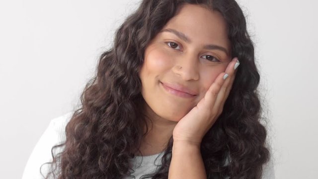 Closeup portrait of young mixed race plus size woman without makeup smiling to the camera