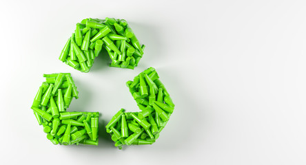 Recycle logo made of heap of green used plastic bottles over white background.