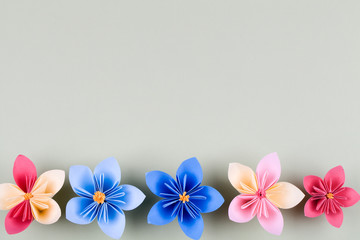 Colourful handmade paper flowers on light blue background