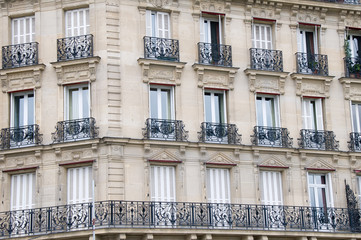 Fototapeta na wymiar Windows and Iron balconies of old apartment buildings in Paris France