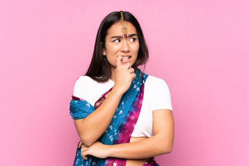 Young Indian woman with sari over isolated background nervous and scared