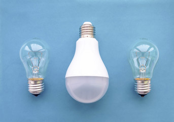 Energy-saving lamp with incandescent lamps in a row on a blue background. The concept of saving energy.