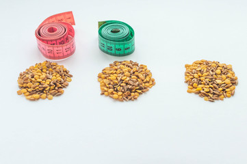 lentils and spelt with a centimeter ribbon on a white background. The concept of losing weight and fighting excess weight. Healthy diet.