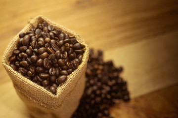 The coffee beans are in a sack and all are placed on a wooden floor.