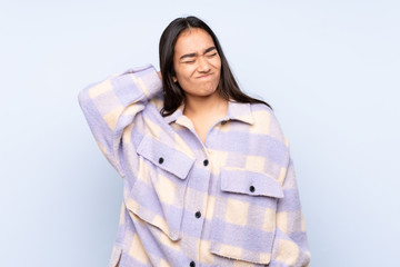 Young Indian woman isolated on blue background with neckache