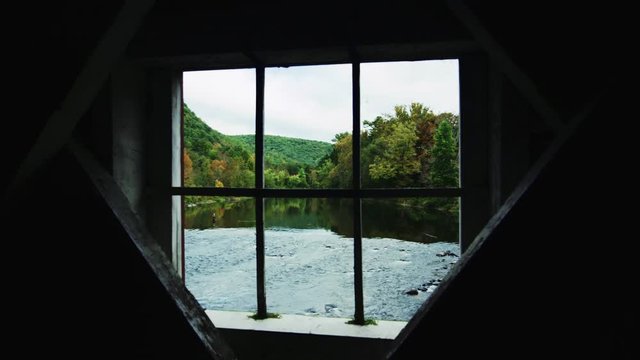 Fly fisherman in distance in scenic New England river autumn foliage through window of covered bridge neutral start kd p400 ptra