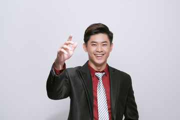 Smart casual man wearing black suit, pointing fingers to forehead standing on white background in studio