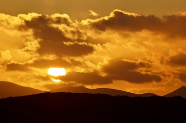 sunset in the mountains with dramatic clouds