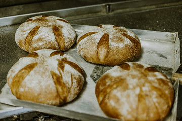 Baking bread. Dough in proofing basket on wooden table with flour, cumin and wheat ears. Top view.
