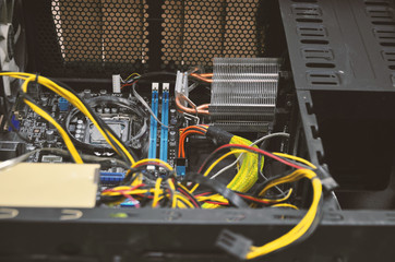 An open computer system unit crammed with powerful wires. Dismantling and cleaning of computer...