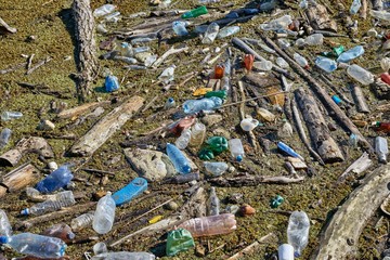Plastic waste drifting in polluted water accumulated at a dam, environmental problems