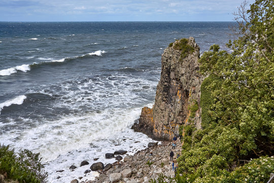 Tourists visiting Jons Kapel (John's Chapel) - a 22-metre high solitary rock which resembles a church tower, Bornholn island, Denmark.